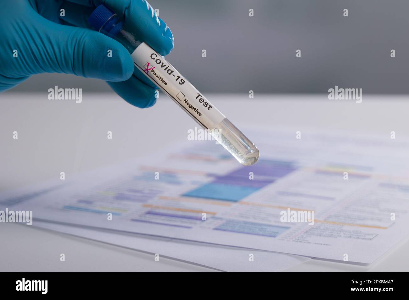 Porter des gants médicaux pour manipuler une sonde sanguine avec indicateur Covid Banque D'Images