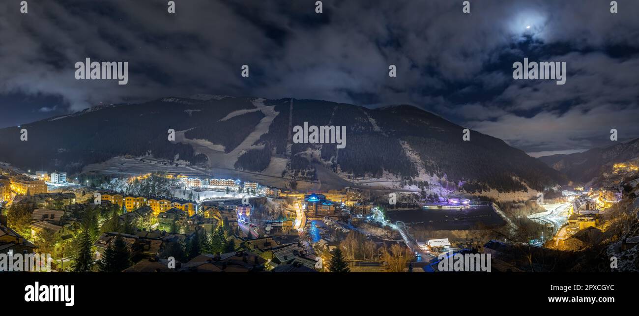 Panorama avec la ville d'El Tarter. Hôtels, centres de villégiature et bâtiments résidentiels éclairés par des lumières de rue la nuit. Vacances d'hiver au ski, Andorre, Pyrénées Banque D'Images