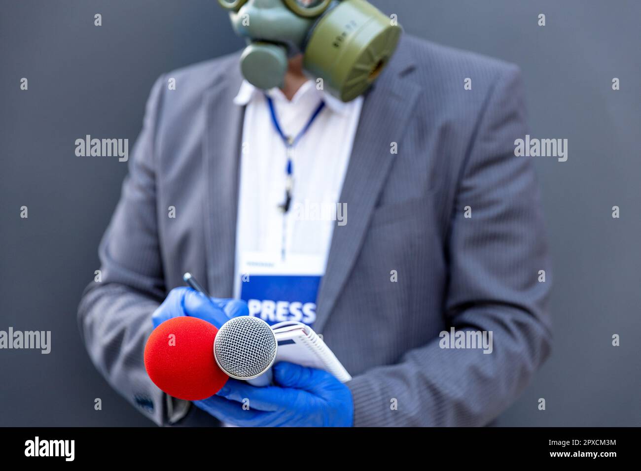Journaliste à une conférence de presse ou à un événement médiatique portant des gants de protection Et masque facial contre la maladie de coronavirus COVID-19 tenant l'écriture de microphone non Banque D'Images