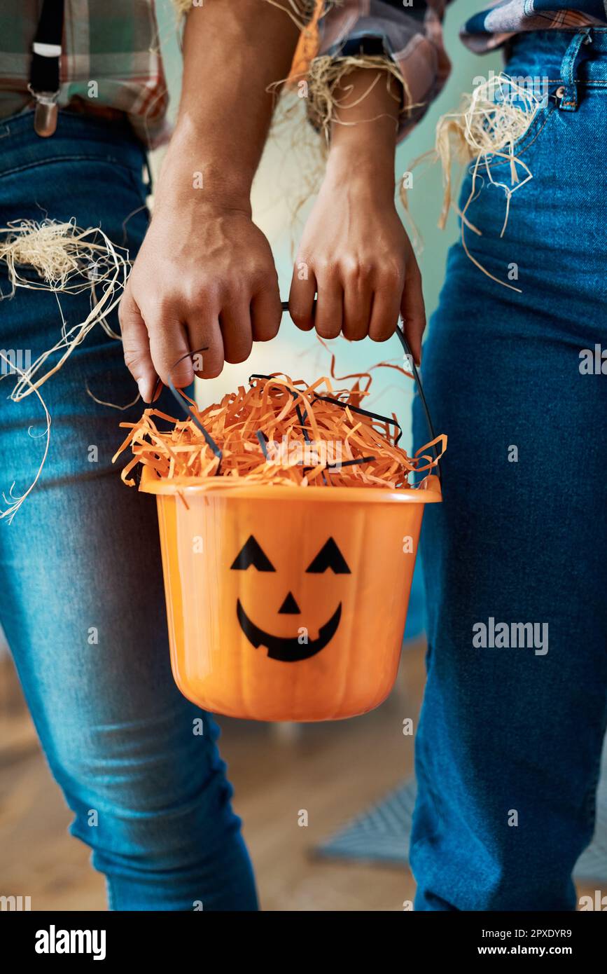 Dans l'humeur pour un tour-ou-traitement. deux personnes méconnaissables tenant un seau à la maison. Banque D'Images