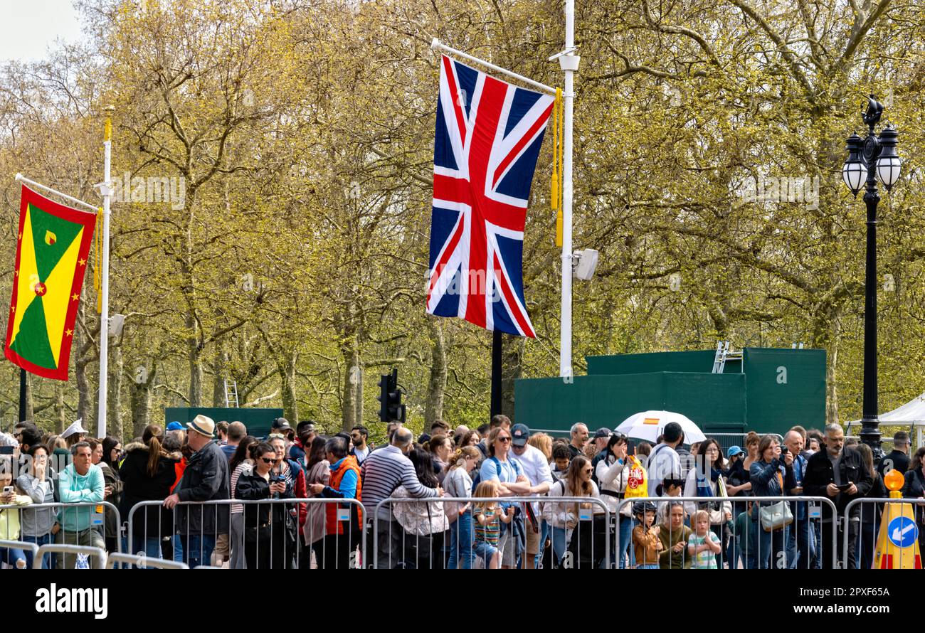Préparatifs pour le couronnement 30th avril 2023 montrant les drapeaux de la Grenade et de l'Union Jack commonwealth avec des gens alignés le long du Mall London UK Banque D'Images