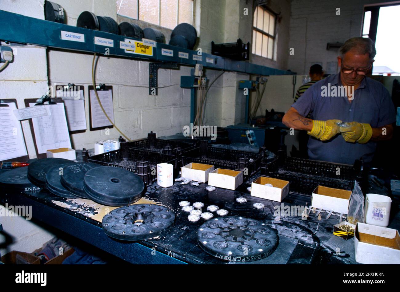 Homme travaillant avec une machine de moulage centrifuge dans un atelier de production de Buckles en Angleterre Banque D'Images
