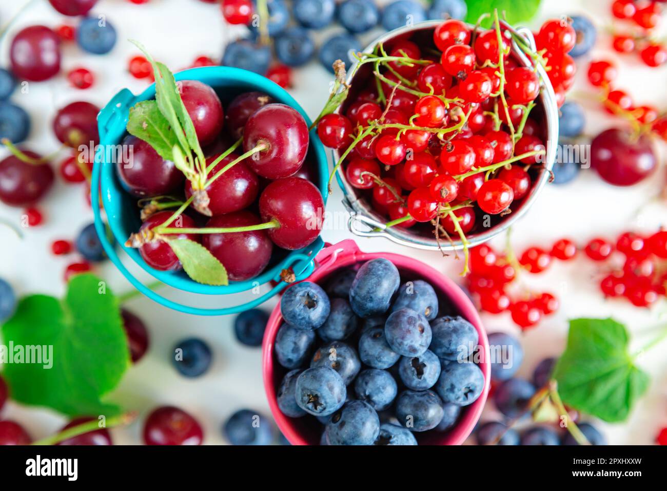 Mélanger les baies fraîches dans de petits seaux. Vue de dessus. Papier peint d'été juteux. Banque D'Images