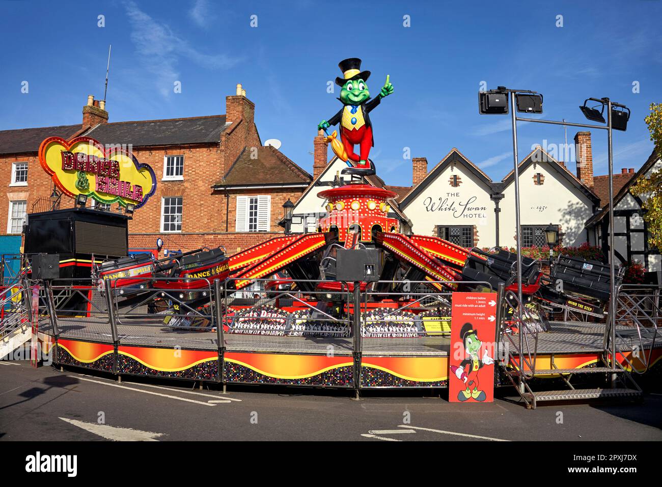 Fairground Waltzers avec Disney Jiminy Cricket England Banque D'Images