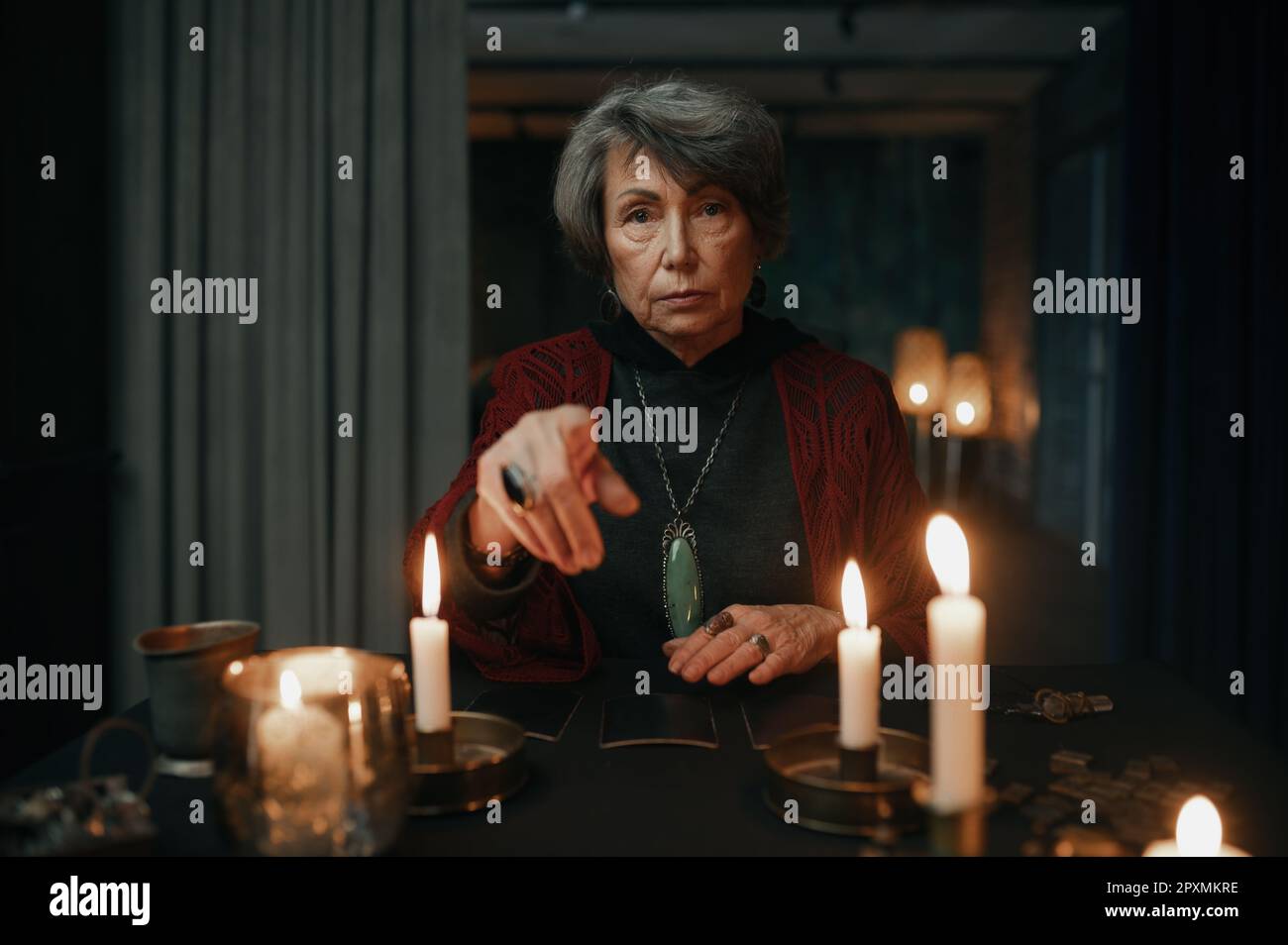 Portrait de teller de fortune gitane avec des cartes de tarot sur la table pointant le doigt et regardant l'appareil-photo. Session de cession en ligne Banque D'Images