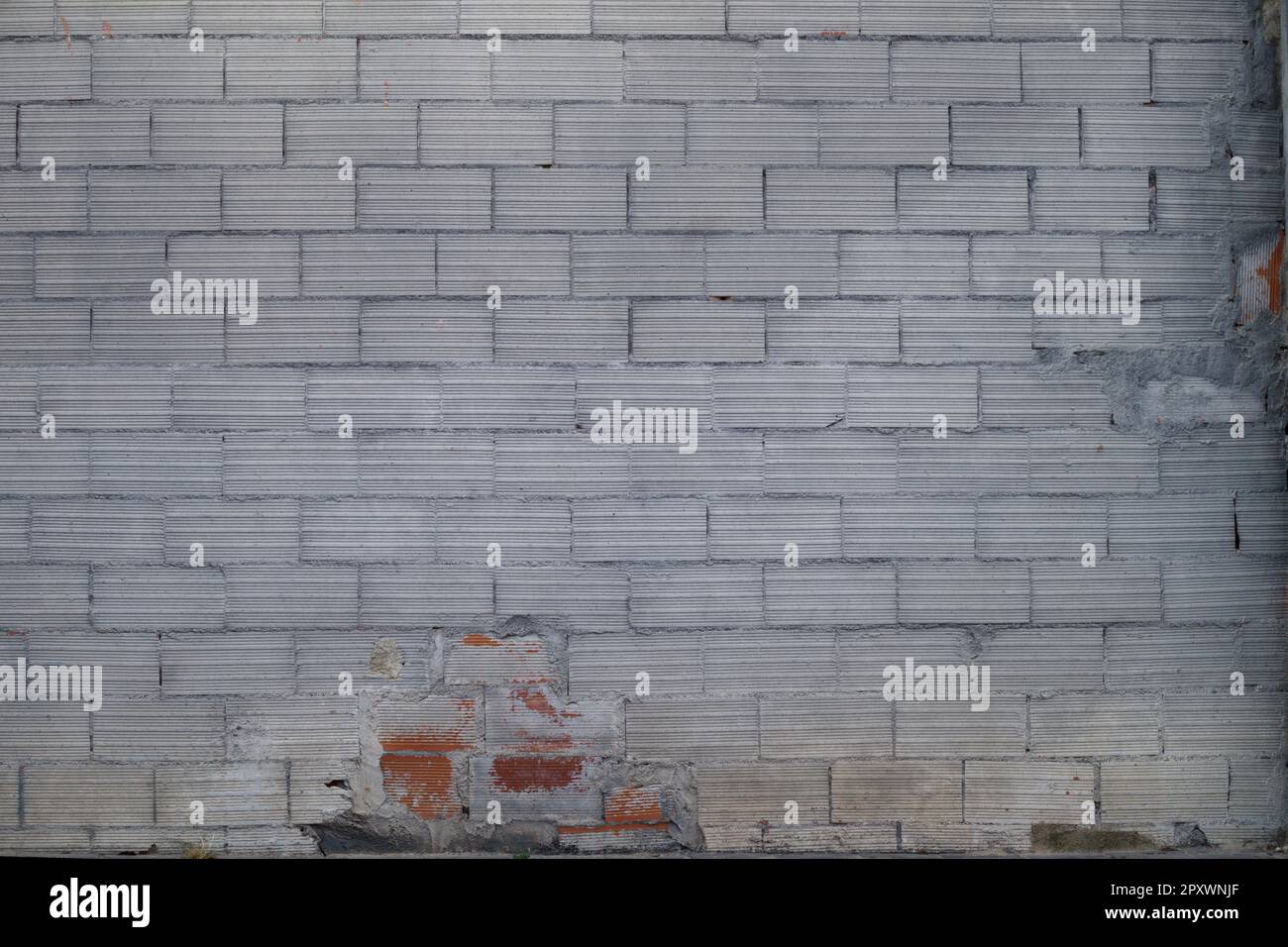 Mur de briques peint en gris dégradé par le temps et la négligence dans le centre d'une ville Banque D'Images
