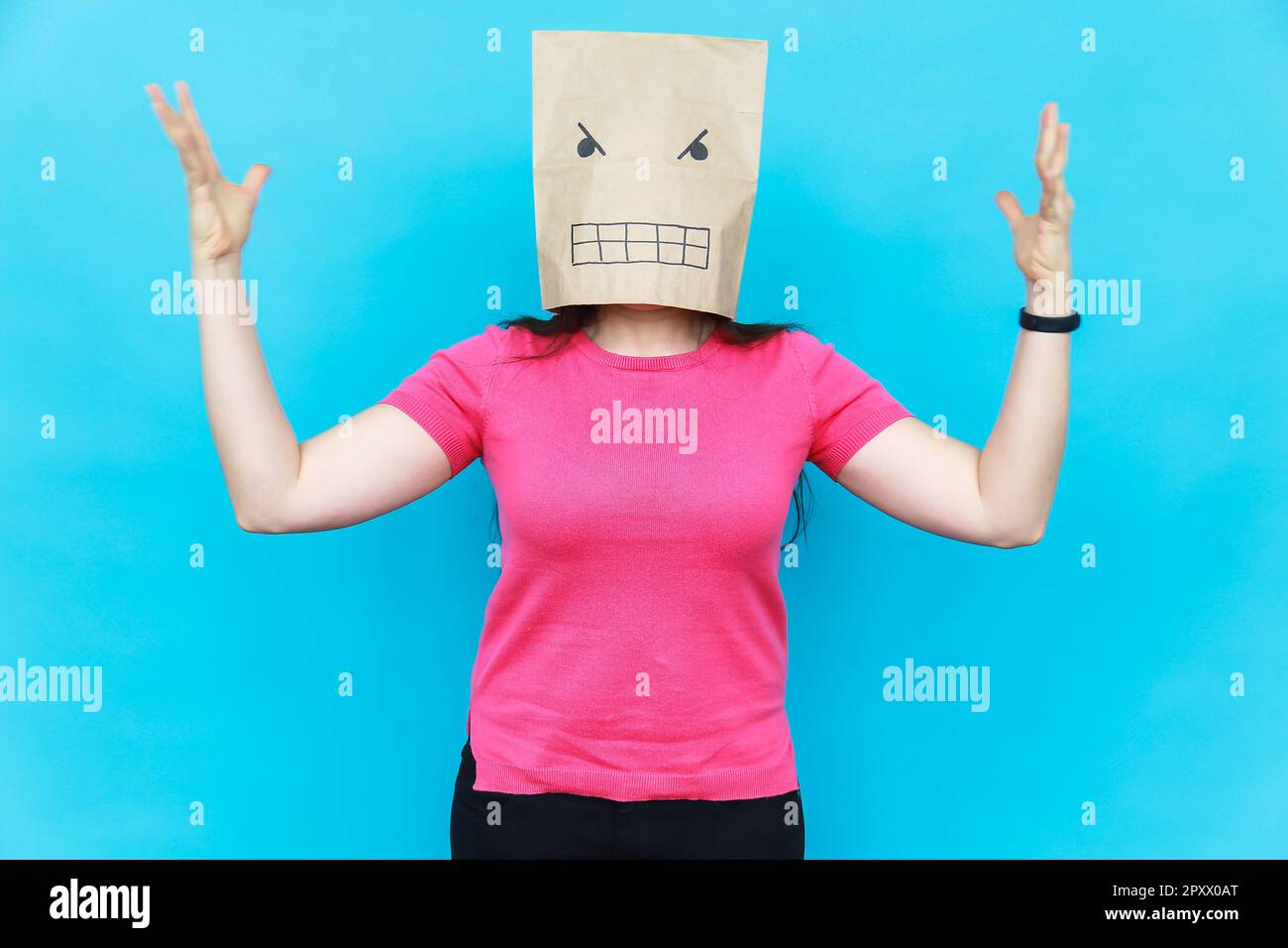Femme debout avec un carton sur sa tête avec un visage en colère. Émotions. Banque D'Images