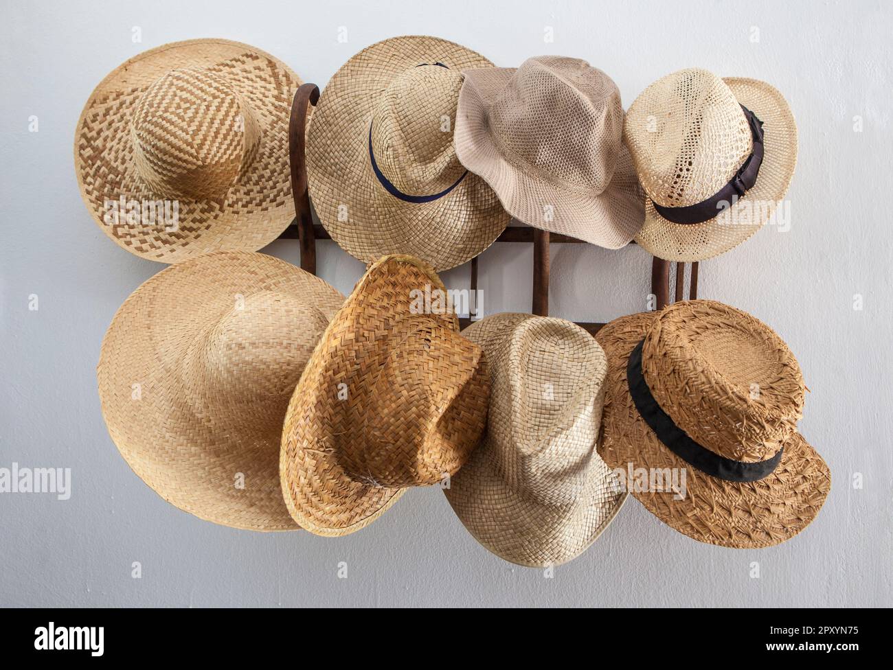 Porte-vêtements encombré de chapeaux en fibres végétales. Style campagnard Banque D'Images