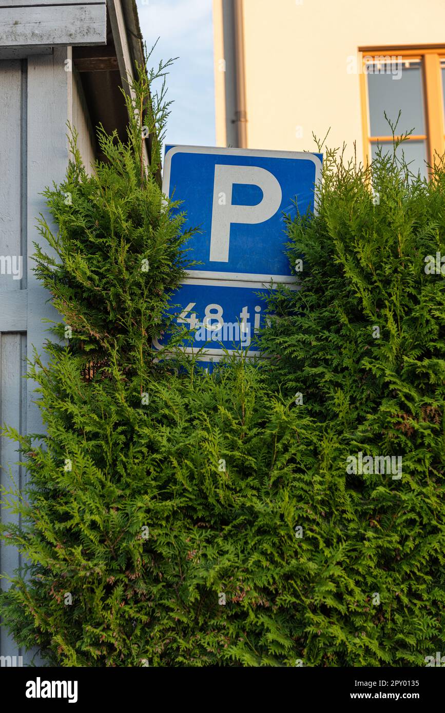 Göteborg, Suède - 01 juillet 2021: Panneau de stationnement partiellement caché par une grande haie. Banque D'Images