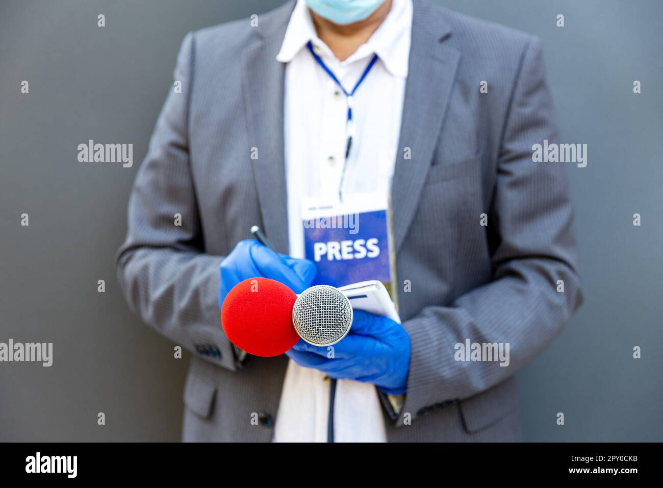 Journaliste à une conférence de presse ou à un événement médiatique portant des gants de protection Et masque facial contre le coronavirus COVID-19 Banque D'Images