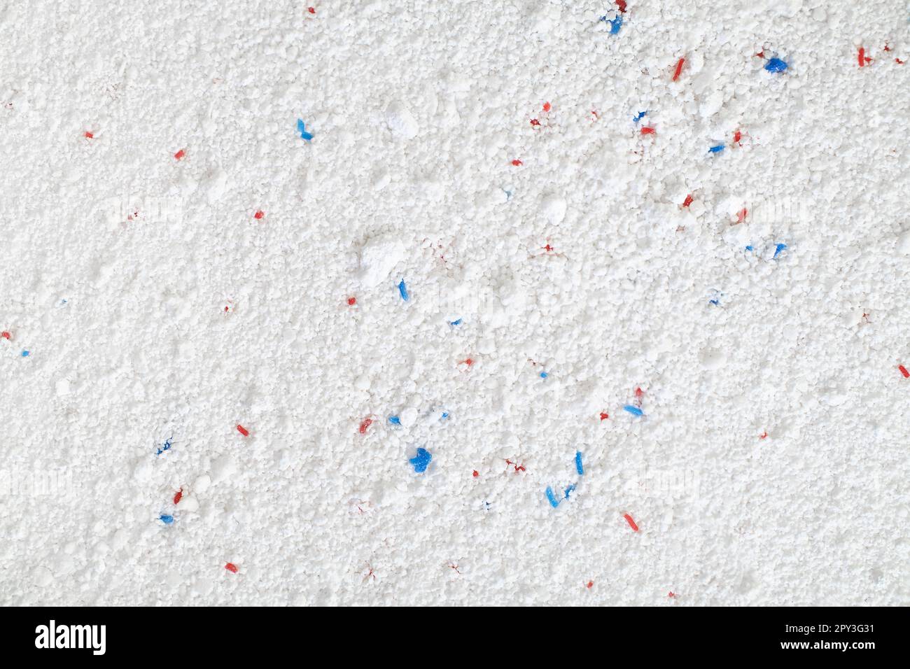 Titre poudre de lavage avec granules bleus et rouges gros plan, vue de dessus. Banque D'Images