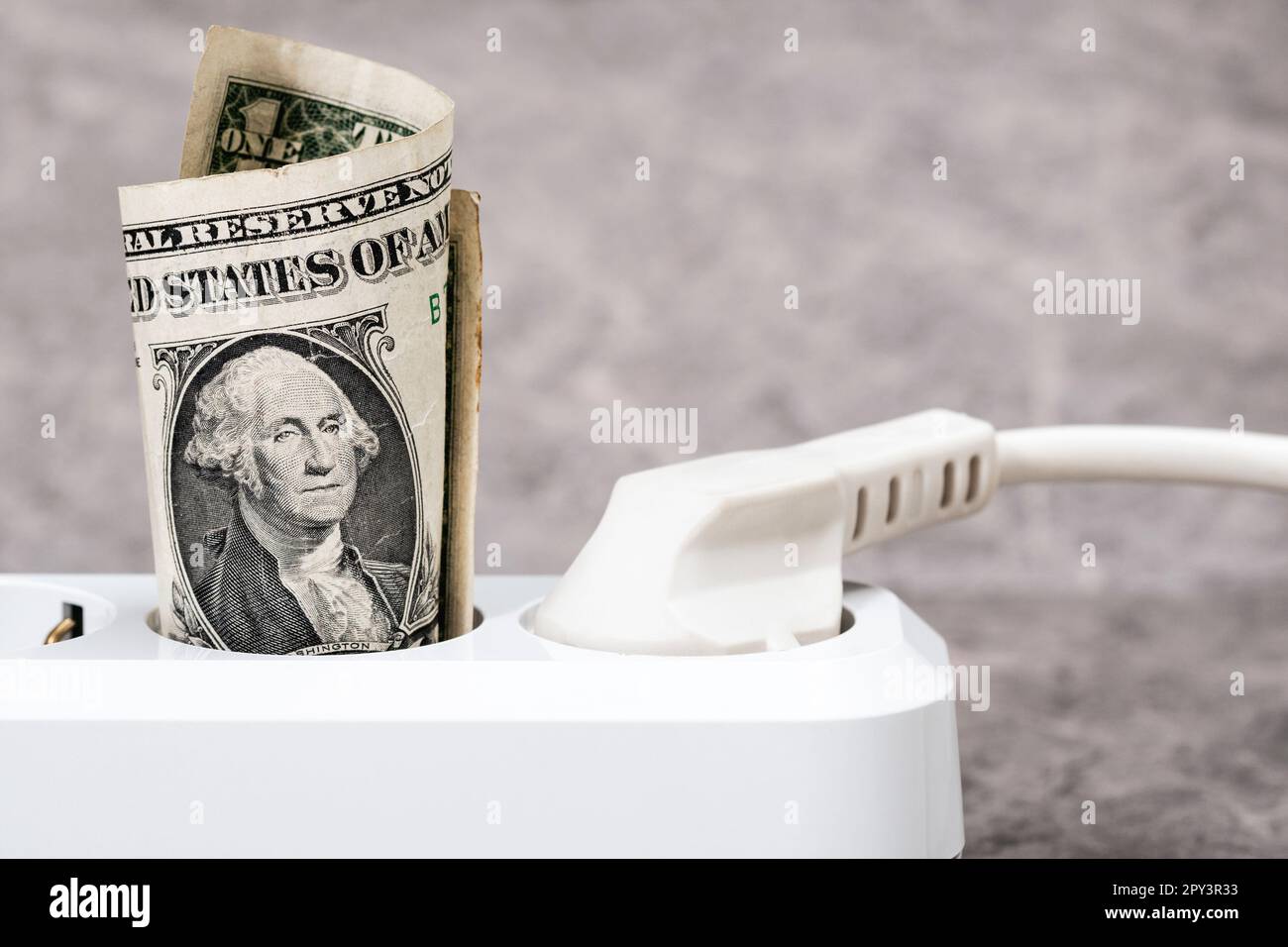 Un dollar branché dans une bande blanche d'alimentation.concept de coûts d'électricité coûteux aux États-Unis et de la hausse des prix de facture d'énergie. Banque D'Images