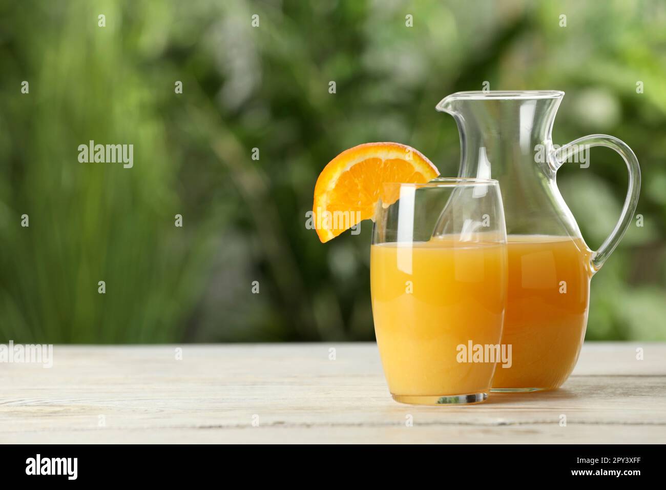 Délicieux jus d'orange en verre et en carafe sur une table en bois blanc  sur fond flou. Espace pour le texte Photo Stock - Alamy
