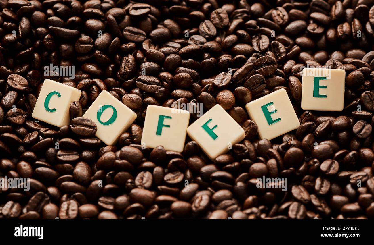 Quelqu'un a-t-il dit café ? Gros plan de lettres en bloc formant le mot café sur une pile de grains de café. Banque D'Images