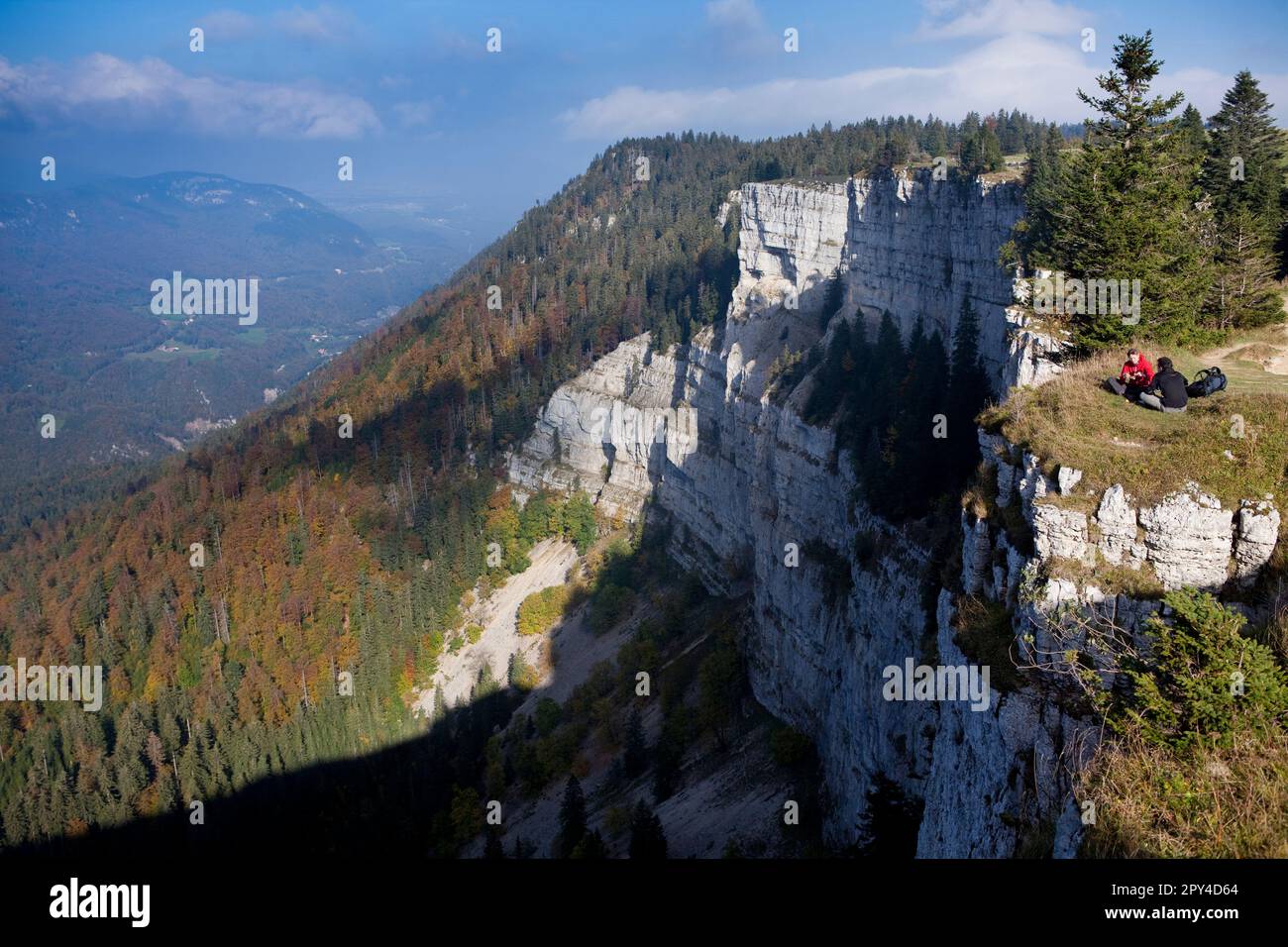 Randonneurs de jour ayant un pique-nique au sommet des falaises du Crux du Van dans les montagnes du Jura suisse. Banque D'Images