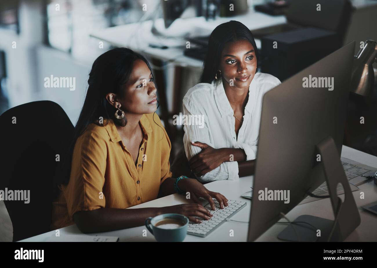 Ajouter des touches finales à leur grand plan. deux jeunes femmes d'affaires travaillent ensemble sur un ordinateur dans un bureau la nuit. Banque D'Images