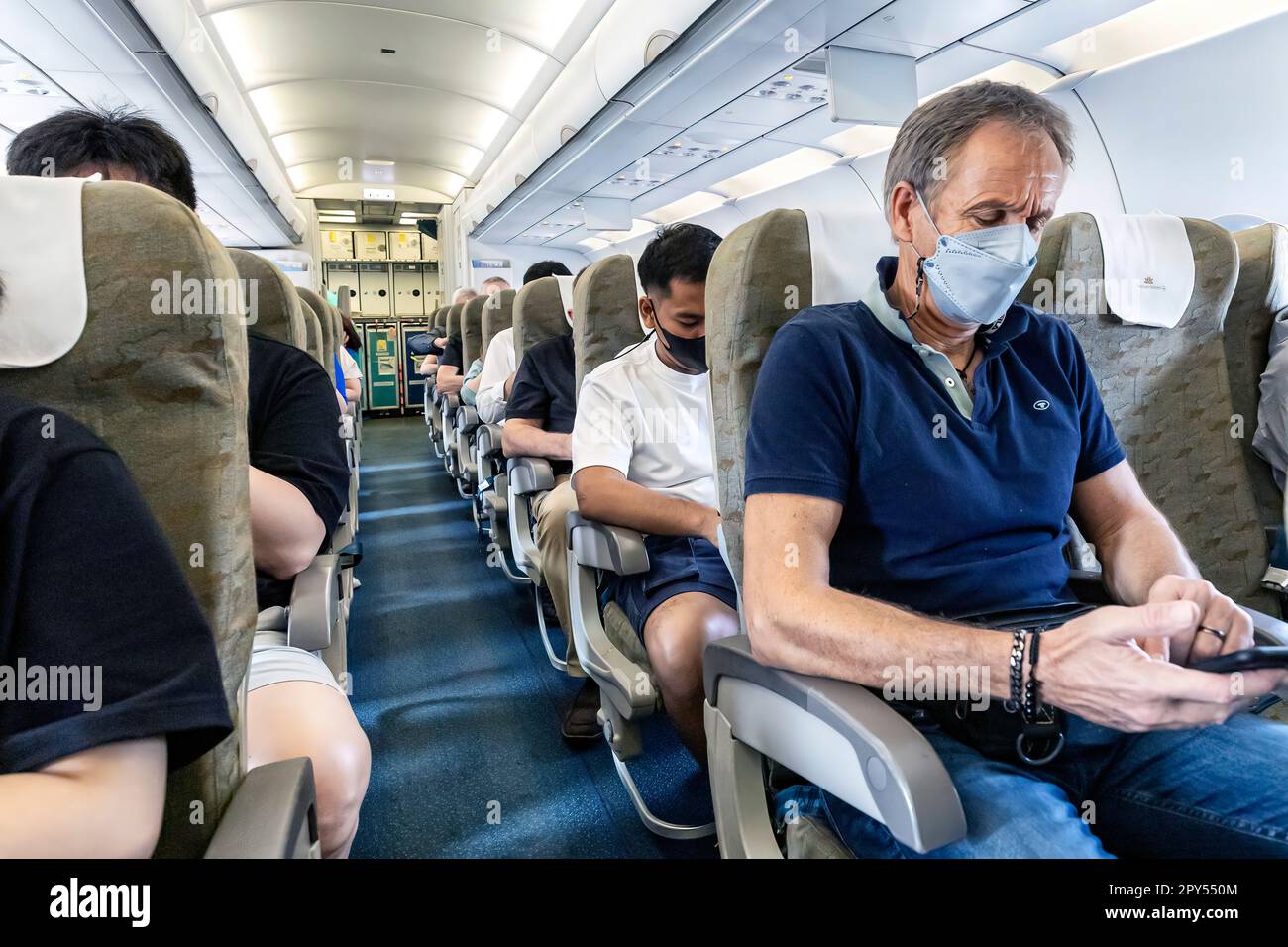 Les passagers de Vietnam Airlines portent des masques faciaux en vol de Bangkok au Vietnam Banque D'Images