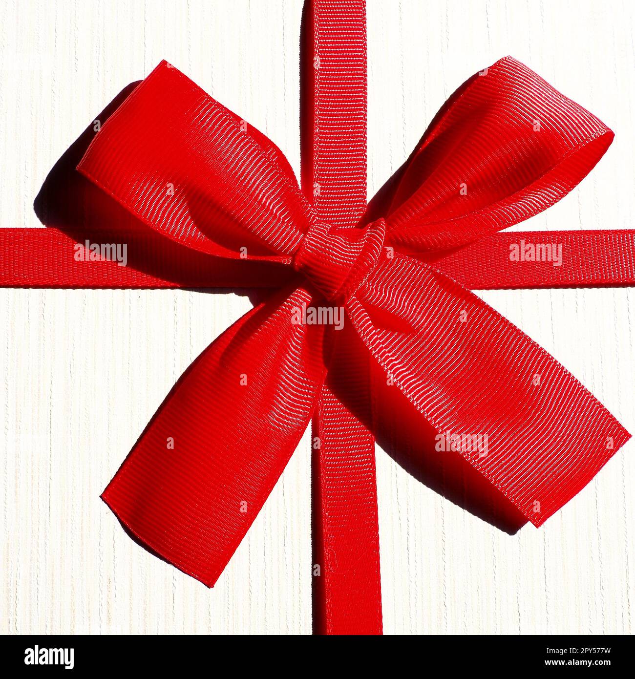 Boîte cadeau blanche avec noeud en ruban rouge isolé sur fond blanc Banque D'Images