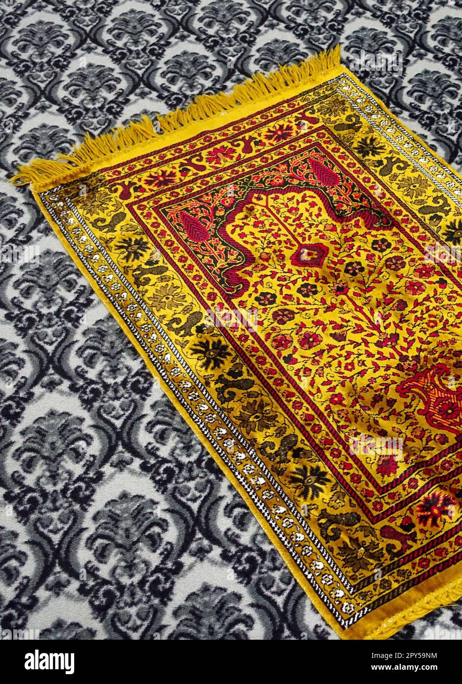 La prière est exécutée sur le tapis de prière mis dans le masjid, le tapis de prière jaune, l'Islam et le tapis de prière Banque D'Images