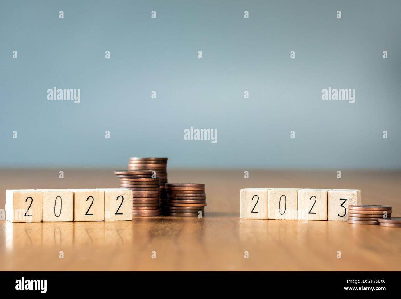 différence entre les économies de la pile de pièces en 2022 et 2023. Économie récession crise, inflation, stagflation, business et perte financière concept. copier l'espace Banque D'Images