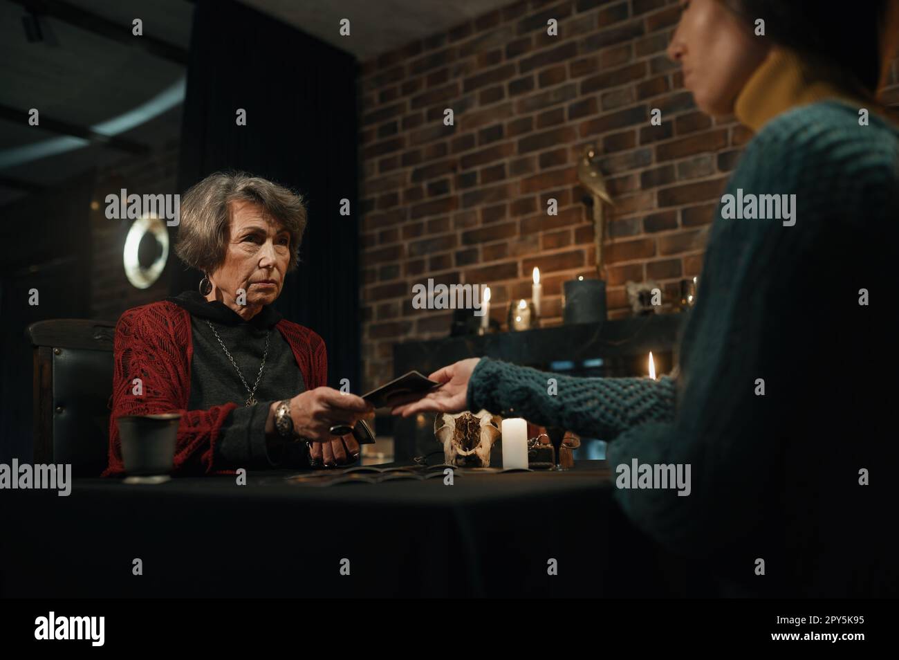 Un tueur de fortune qui donne une session spirituelle avec une carte de tarot pour la jeune femme Banque D'Images