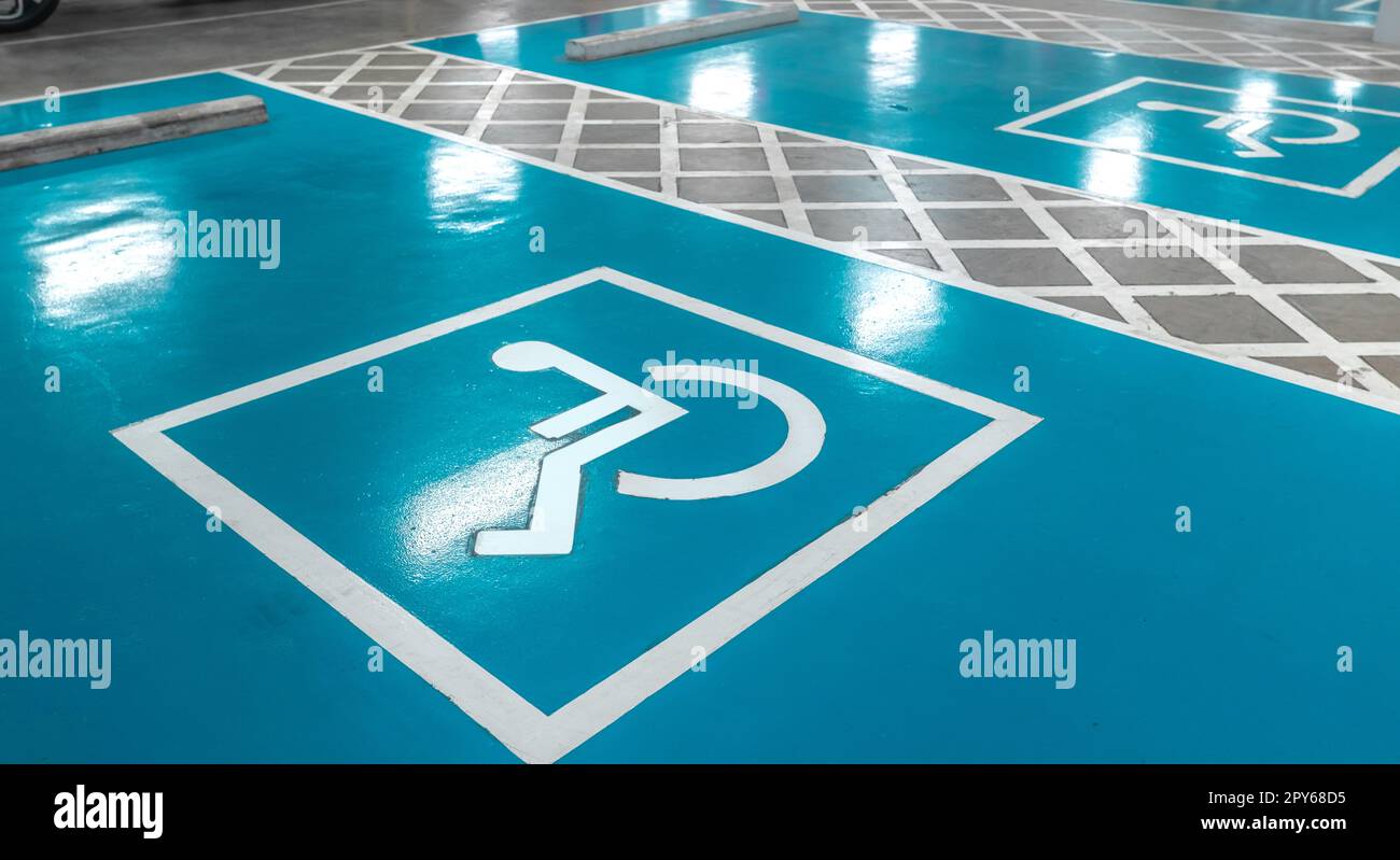 Parking réservé aux conducteurs handicapés dans un supermarché ou un centre commercial. Parking pour personnes à mobilité réduite. Panneau pour fauteuil roulant peint sur le parking. Parking handicapés bleu et blanc. Banque D'Images