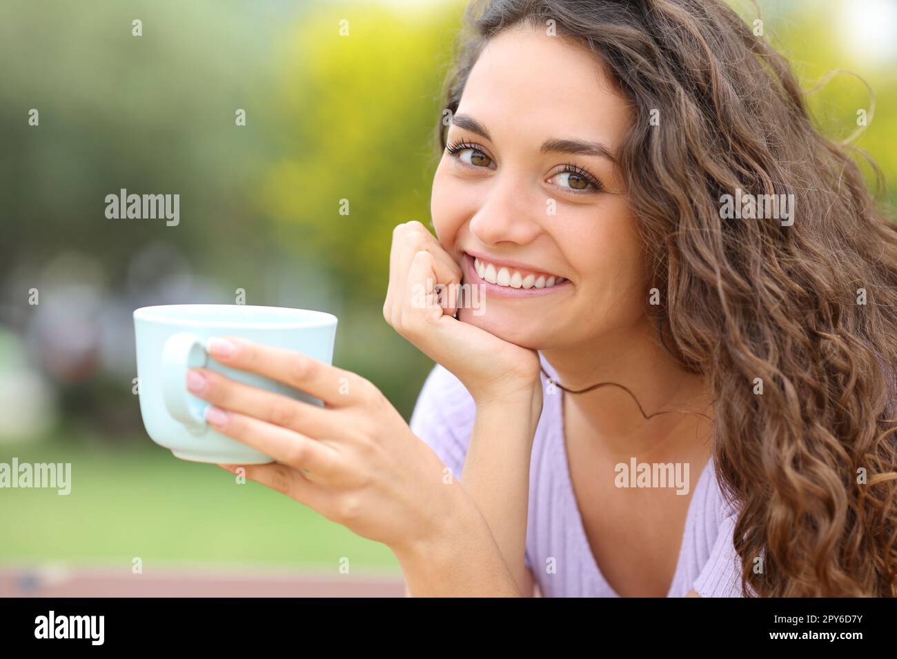 Bonne femme tenant une tasse de café posant Banque D'Images