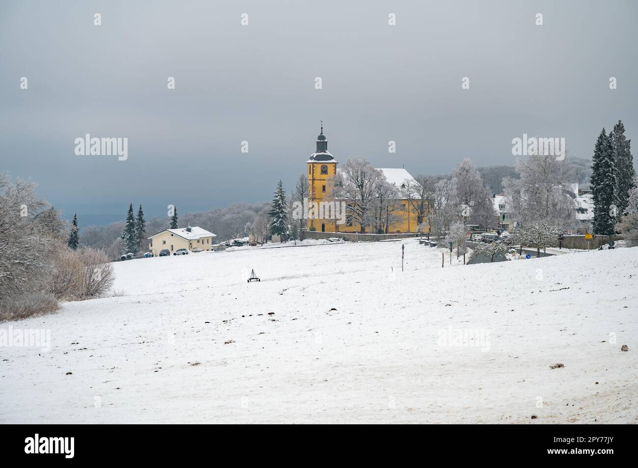 Neunkircher hoehe près de darmstadt en hiver avec beaucoup de neige et église jaune en arrière-plan, jour nuageux, allemagne Banque D'Images