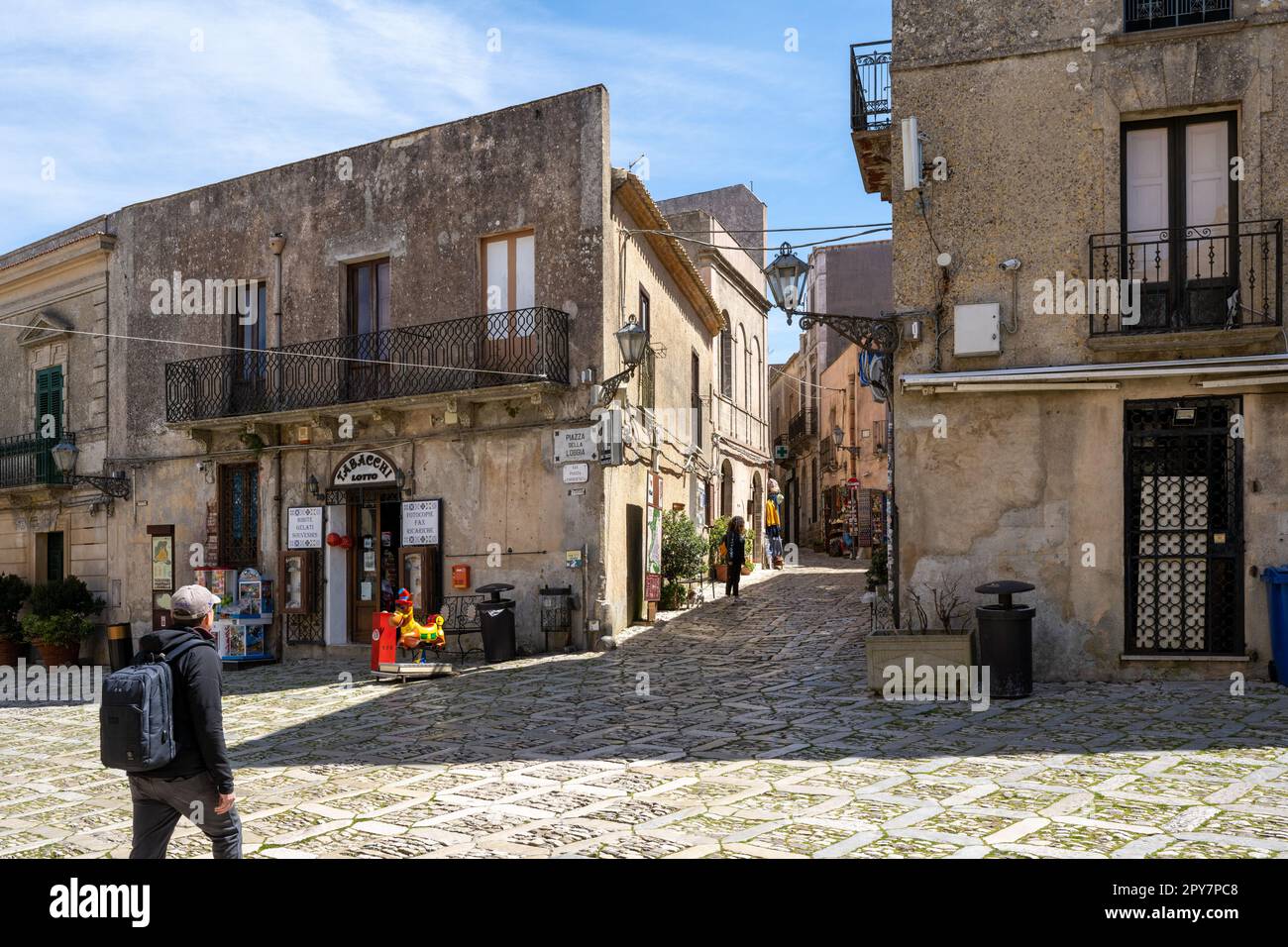 Une place au centre de la ville médiévale d'Erice en Sicile Italie avec ses pavés carrés typiques et ses maisons méditerranéennes beiges au soleil. Banque D'Images