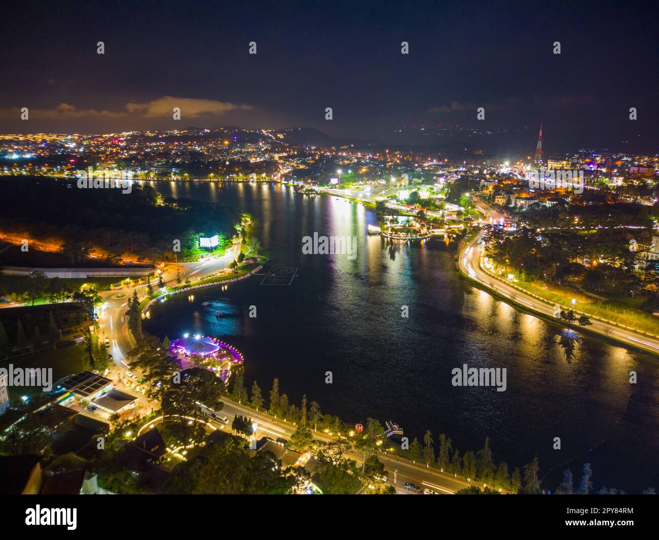 Vue nocturne captivante du lac Xuan Huong dans la ville de Da Lat, Vietnam : le mélange parfait de lumières de la ville et des eaux de Serene Banque D'Images