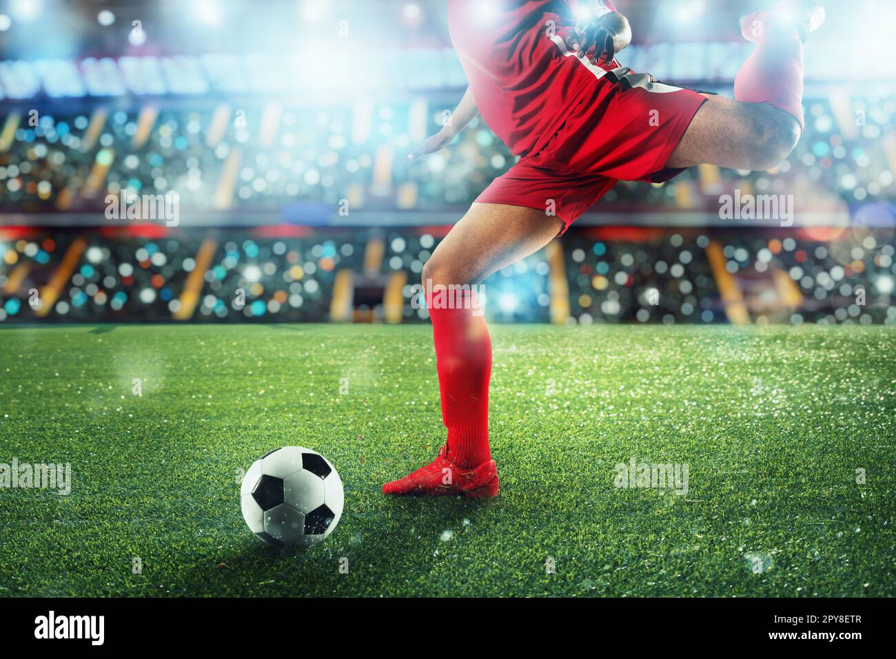 Scène de nuit football match avec player Kicking the ball avec puissance. Banque D'Images