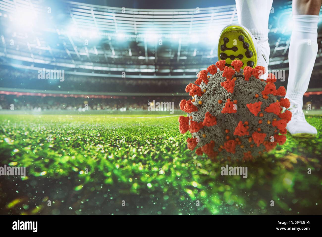 Joueur de football avec virus ball sous la chaussure de football au stade Banque D'Images