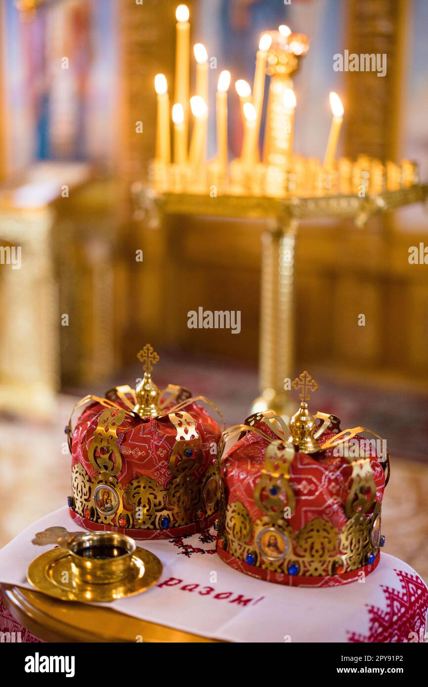 Vue rapprochée des couronnes de mariage sur une serviette brodée lors d'une  cérémonie de mariage dans l'église orthodoxe ukrainienne sur fond de  bougies. Traduction Photo Stock - Alamy