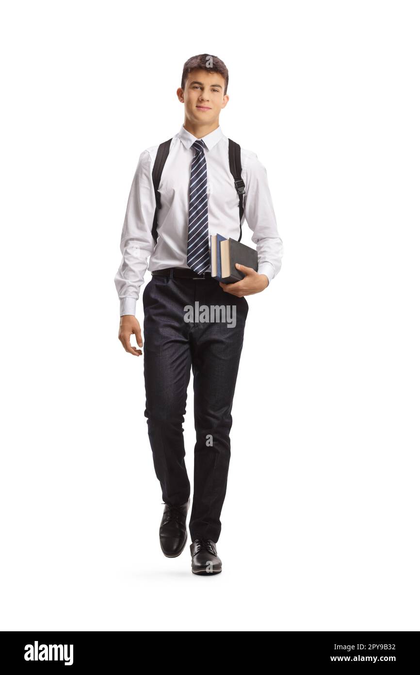 Portrait complet d'un étudiant mâle portant des livres et marchant vers l'appareil photo isolé sur fond blanc Banque D'Images