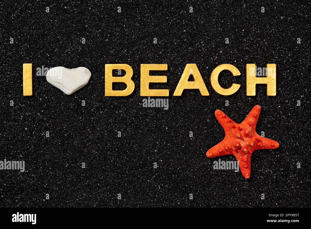 I Love Beach - lettres d'or en sable noir et étoile de mer Banque D'Images