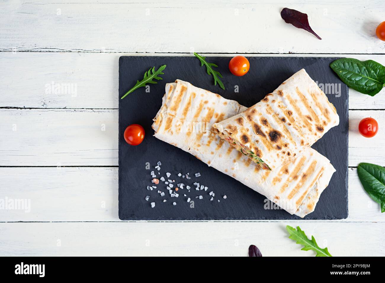 Délicieux sandwich au poulet shawarma avec salade et fromage sur fond de bois Banque D'Images