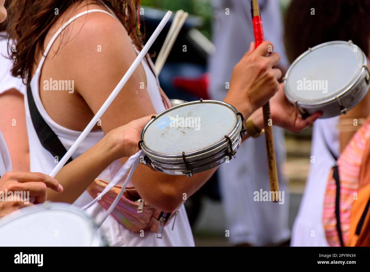 Femme jouant du tambourin dans des rues brésiliennes bondées pendant les festivités du carnaval, au Brésil Banque D'Images