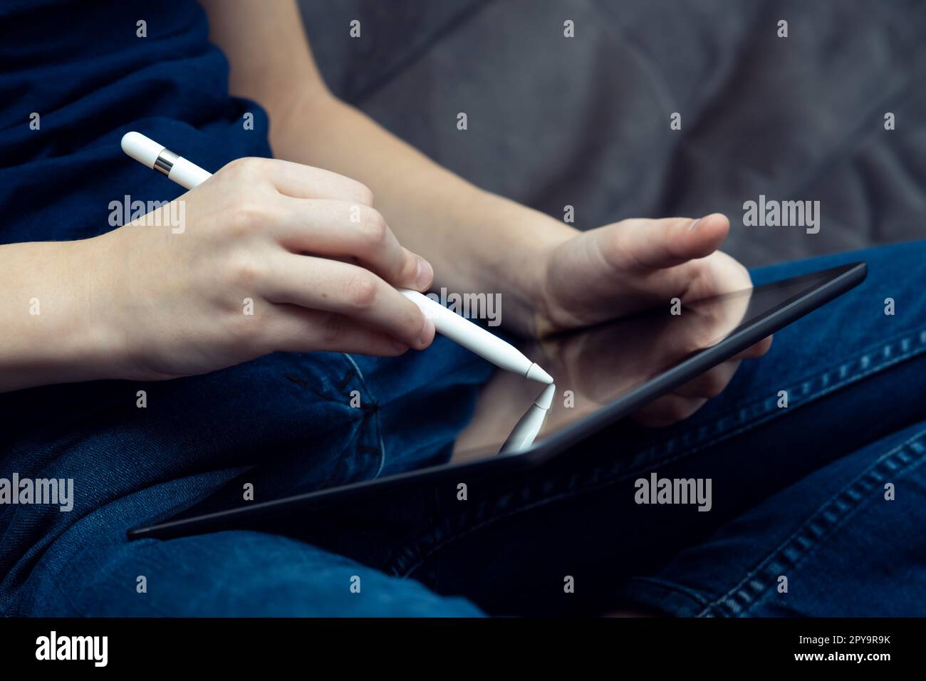 Tablette numérique dans les mains masculines, vue de côté gros plan. Jeune homme d'affaires travaillent sur le gadget multitâche avec stylet. Banque D'Images