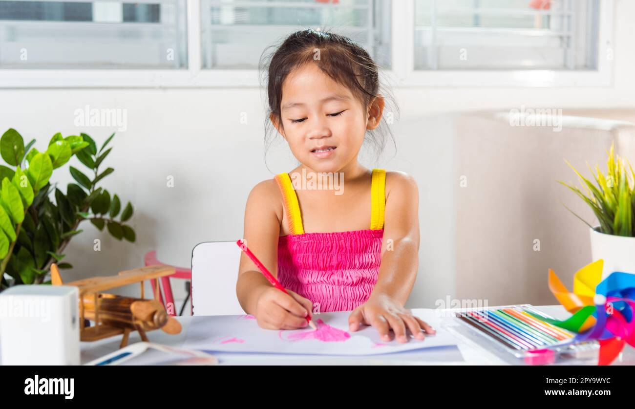 Joyeux enfant petite fille coloré dessin coeur rose sur papier blanc Banque D'Images