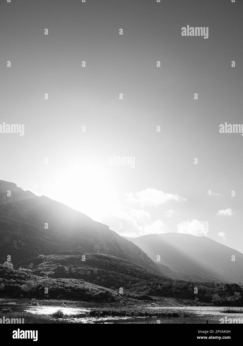 Vue depuis le Gap of Dunloe dans le comté de Kerry, en Irlande. Les rayons du soleil se dirigent sur les montagnes et dans la vallée en contrebas. Banque D'Images