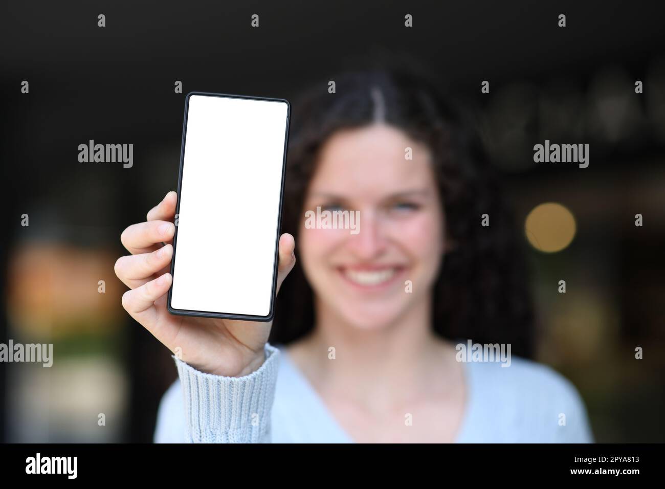 Femme heureuse montrant à la caméra téléphone vierge Banque D'Images