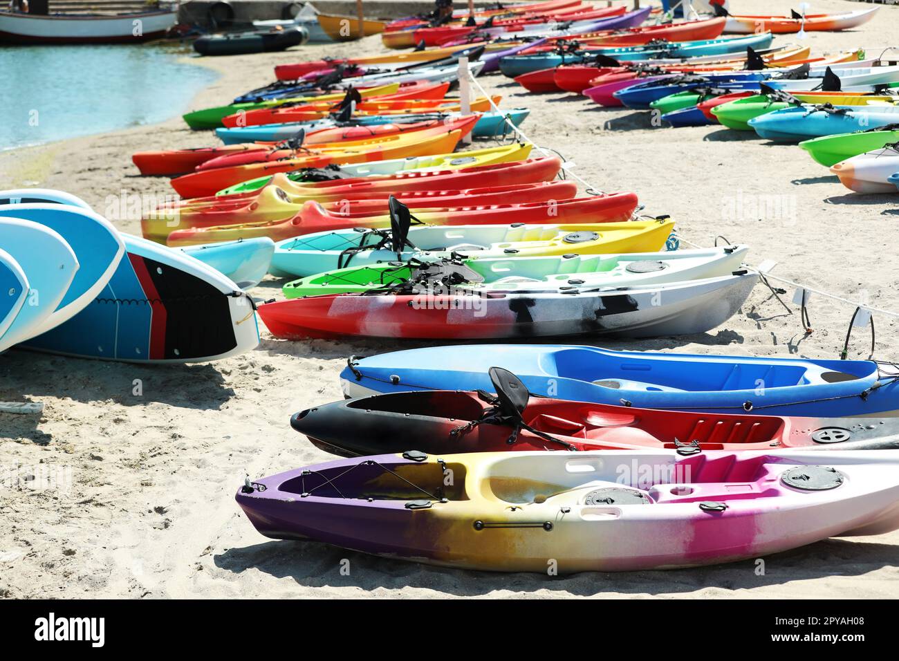 Beaucoup de kayaks colorés sur le sable près de la mer Banque D'Images Beaucoup de kayaks colorés sur le sable près de la mer Banque D'Images