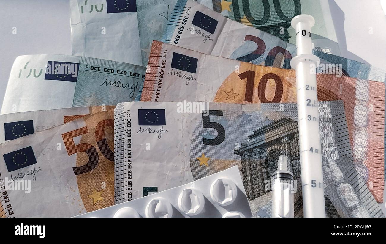 Billets en euros. Monnaie européenne sur fond blanc gros plan. Emballage blanc avec des pilules et une seringue de mesure à côté de l'argent. Le coût élevé du traitement. Billets de 5, 10, 20, 50, 100 euros Banque D'Images