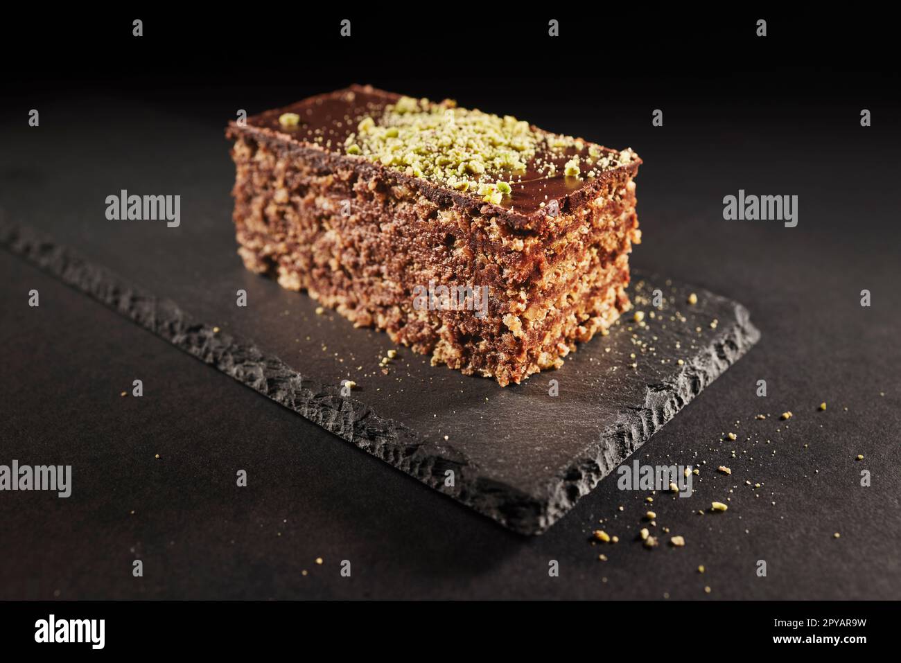 Gâteau au chocolat avec noix et pistache isolés sur fond noir. Pâtisserie de la boulangerie maison Banque D'Images