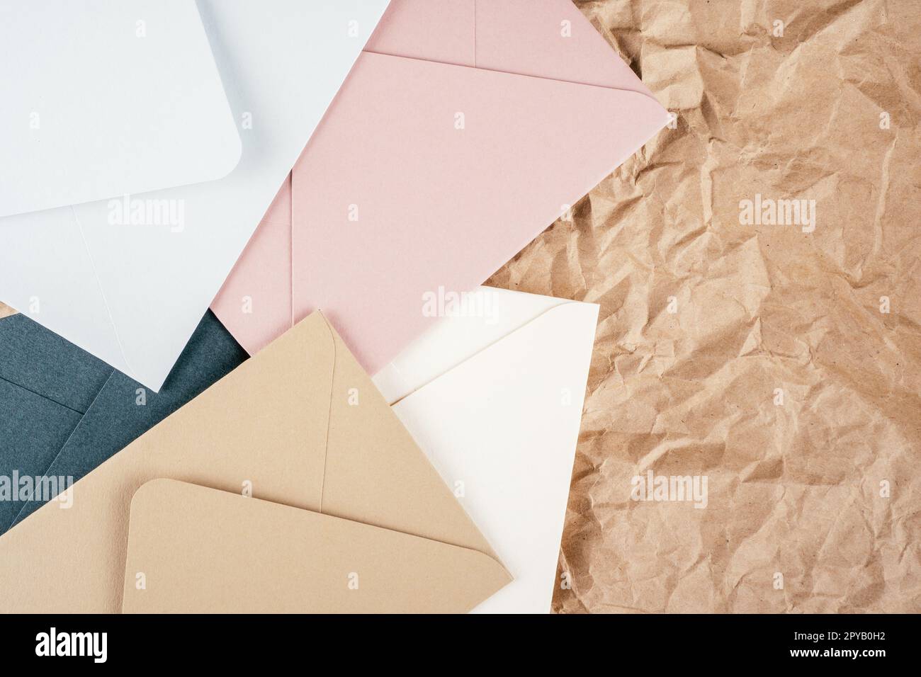 Image de fond de papier kraft texturé froissé rugueux avec des enveloppes en carton multicolore. Vue de dessus. Espace de copie Banque D'Images