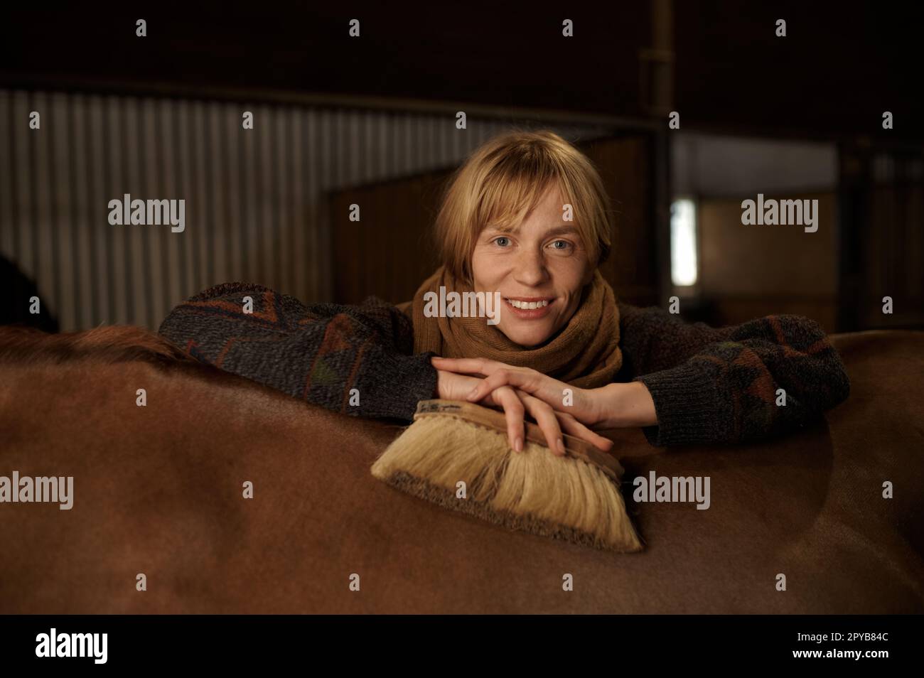 Portrait de jeune homme souriant derrière un cheval Banque D'Images