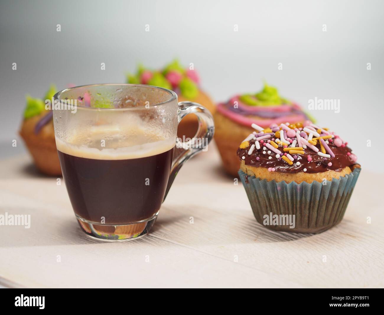 Muffins avec décoration colorée et café sur table blanche Banque D'Images