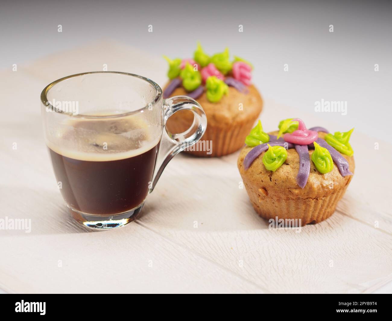 Muffins avec décoration colorée et café sur table blanche Banque D'Images