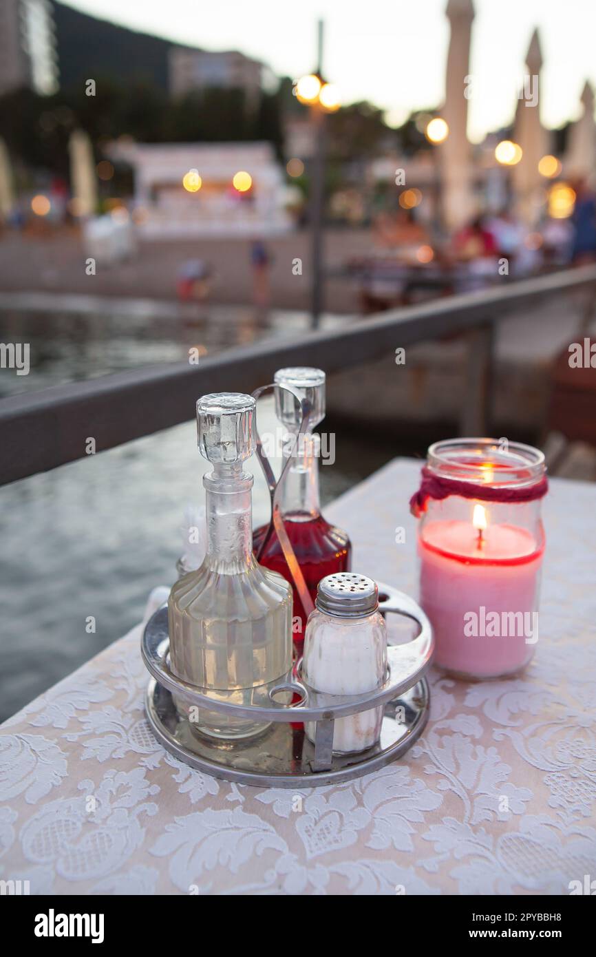La terrasse du restaurant au bord de la mer, il y a une bougie sur la table. Dans le contexte d'une belle ville de villégiature. Dîner romantique au bord de la mer. Banque D'Images