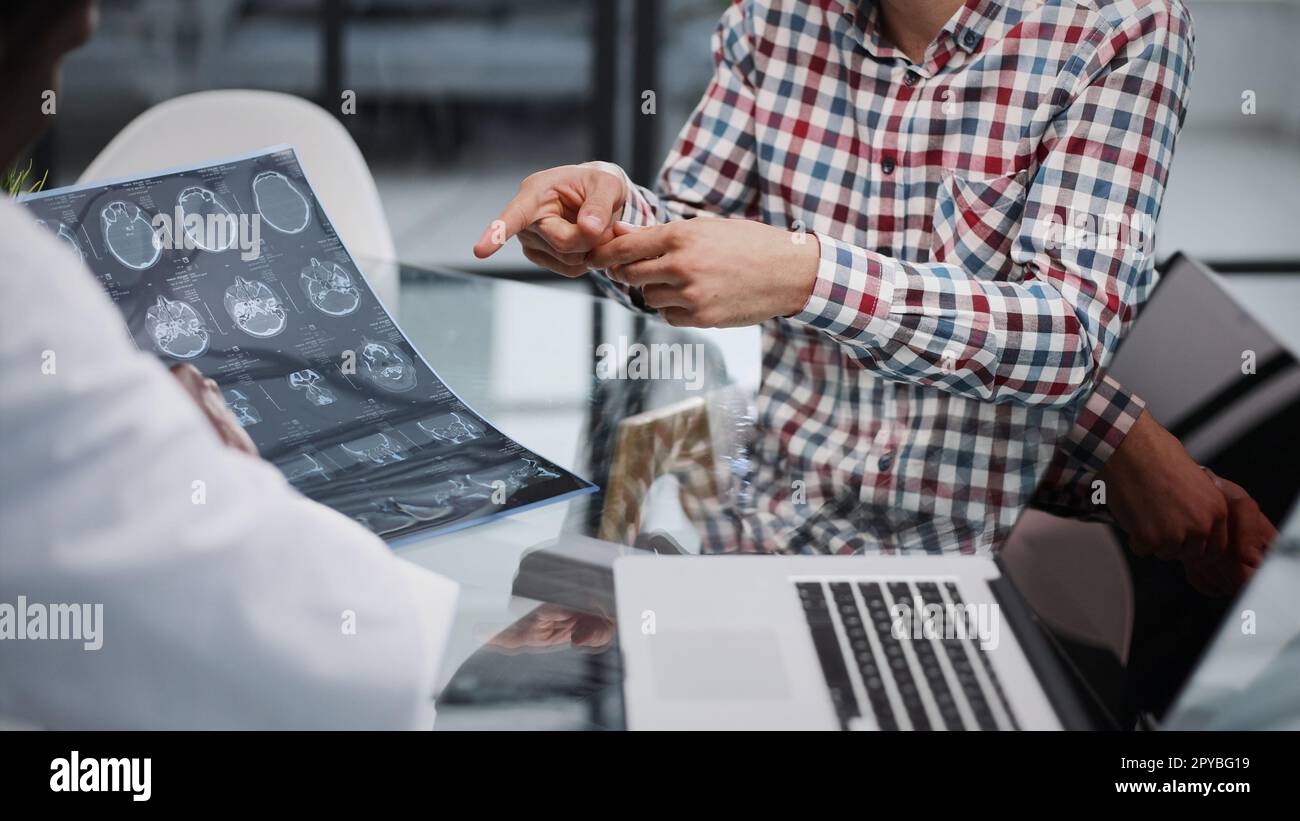 le médecin et le patient à la réception discutent de la radiographie Banque D'Images